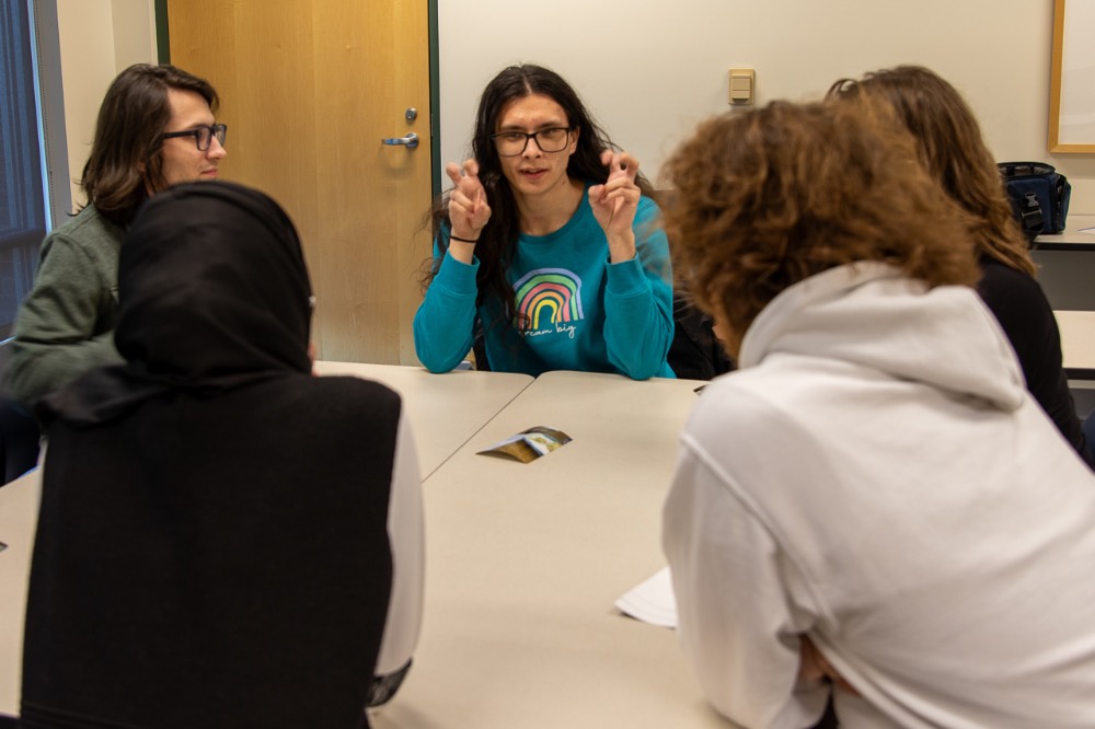 Girl using air quotes with group